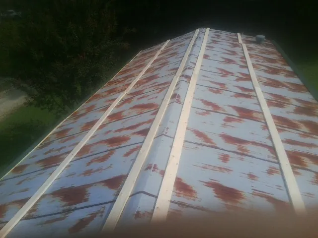 Rusted metal roof panels with new wood purlins before replacement — Storm Damage Roof Repair in Albemarle by Roofing Brothers