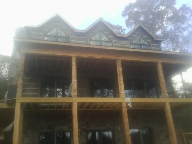 Dormers and porch framing on a large log home under construction — Roof Coating work by our crew in Albemarle