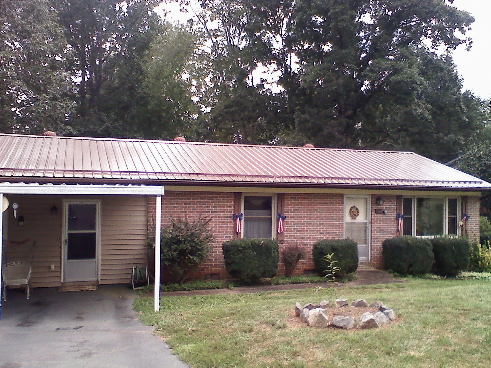 Bronze metal roof and carport on a brick ranch home — Roof Repair work by our crew in Albemarle